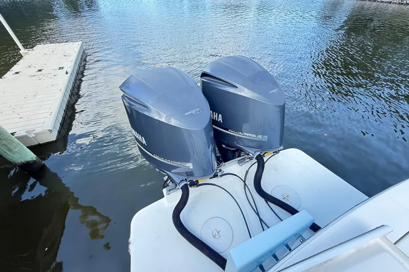 Slide: The Image of 2009 Regulator 34SS boat docked, featuring Garmin equipment, surrounded by serene water and trees. - 34