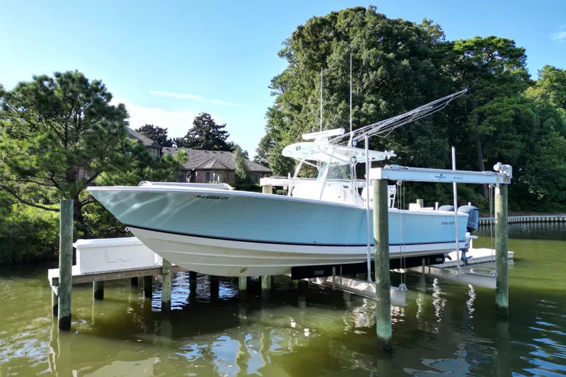 Slide: The Image of 2009 Regulator 34SS boat docked by waterfront home, surrounded by trees. - 4