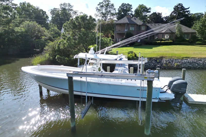 Slide: The Image of 2009 Regulator 34SS boat docked on a lift near a waterfront home. - 5