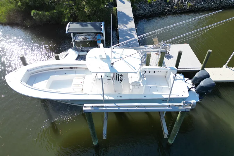 Slide: The Image of 2009 Regulator 34SS boat on lift, surrounded by trees and waterfront homes. - 6