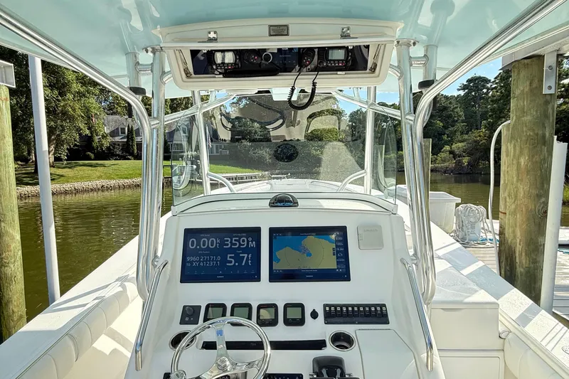 Slide: The Image of 2009 Regulator 34SS boat cockpit with navigation screens and steering wheel at dock. - 8