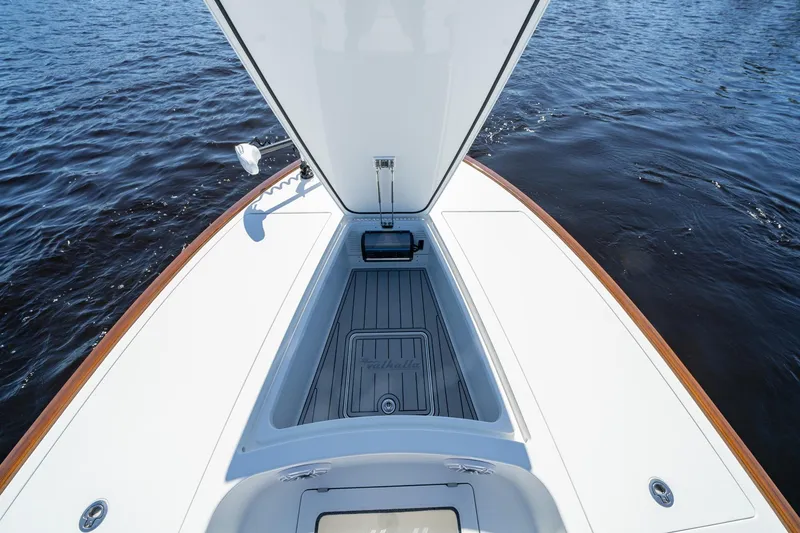 Slide: The Image of 2026 Valhalla Boatworks V-28 Bay deck with open storage compartment on calm water. - 12