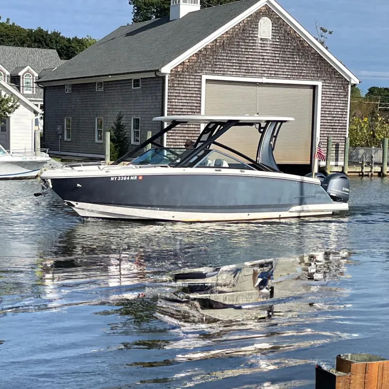 The Image of 2020 Chaparral 280 OSX boat docked near a wooden boathouse. - 0