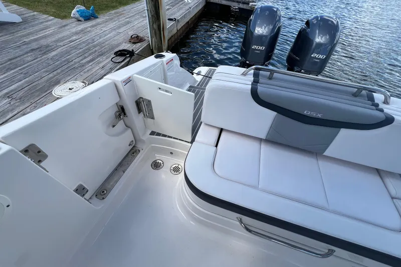 Slide: The Image of 2020 Chaparral 280 OSX boat interior with seating and twin engines by the dock. - 14
