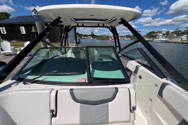 Slide: The Image of 2020 Chaparral 280 OSX boat docked by a scenic waterfront with clear skies. - 17
