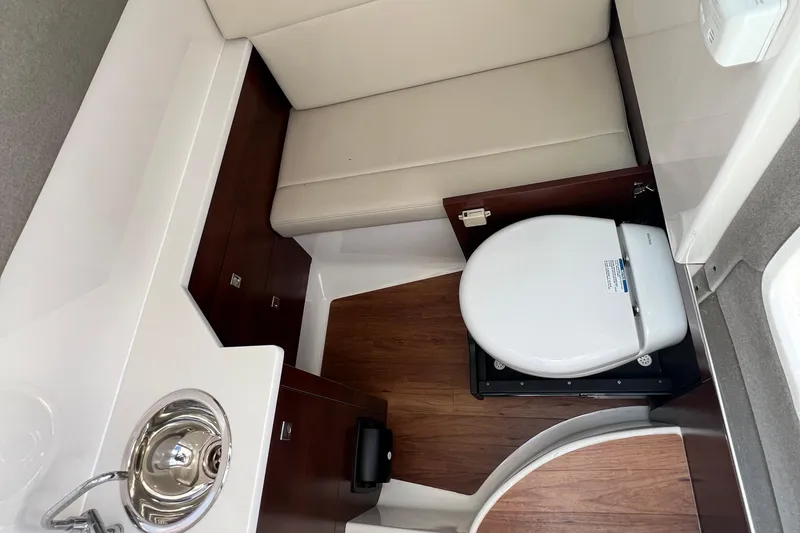 Slide: The Image of 2020 Chaparral 280 OSX boat interior with compact bathroom and sink. - 3