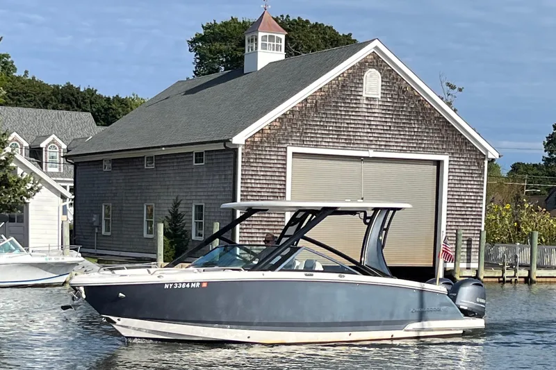 Slide: The Image of 2020 Chaparral 280 OSX boat docked near a rustic boathouse. - 4