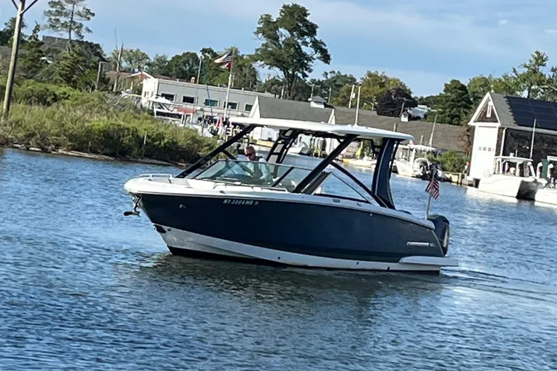 Slide: The Image of 2020 Chaparral 280 OSX boat cruising on a calm river near a marina. - 44
