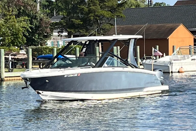 Slide: The Image of 2020 Chaparral 280 OSX boat on calm water near docks and trees. - 5