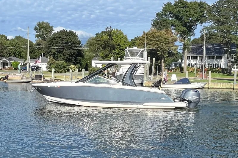 Slide: The Image of 2020 Chaparral 280 OSX boat on a calm lake near a residential area. - 8