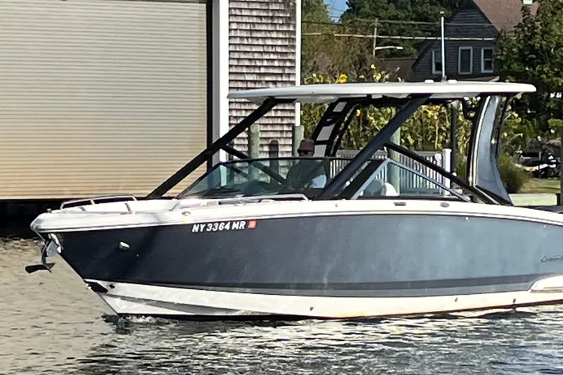 Slide: The Image of 2020 Chaparral 280 OSX boat docked near a waterfront building. - 9