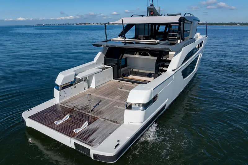Slide: The Image of 2024 Bluegame BGX63 yacht on calm water, showcasing sleek design and spacious deck. - 20