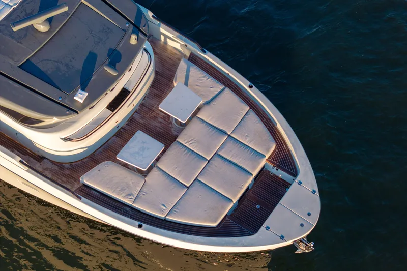 Slide: The Image of 2024 Bluegame BGX63 yacht deck with sun loungers and tables, aerial view. - 24