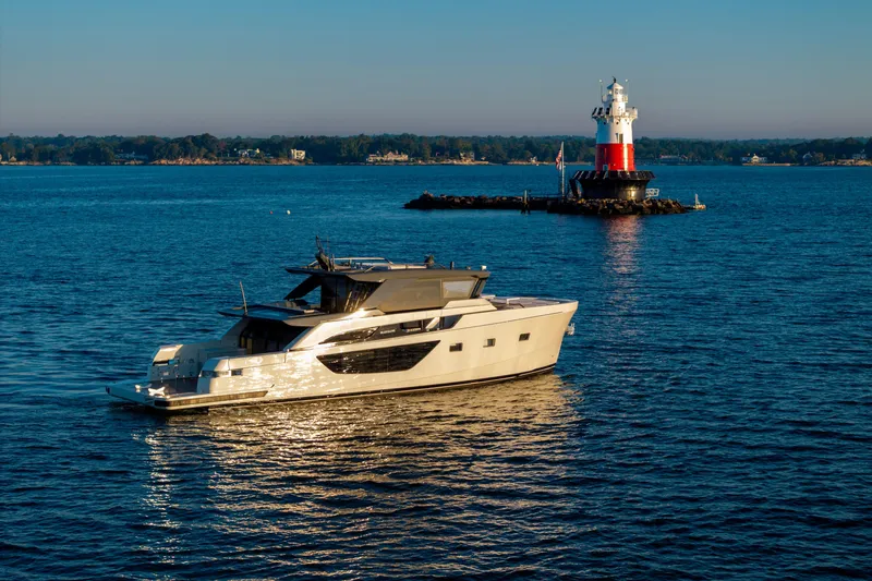 Slide: The Image of 2024 Bluegame BGX63 yacht cruising near a lighthouse on a sunny day. - 7