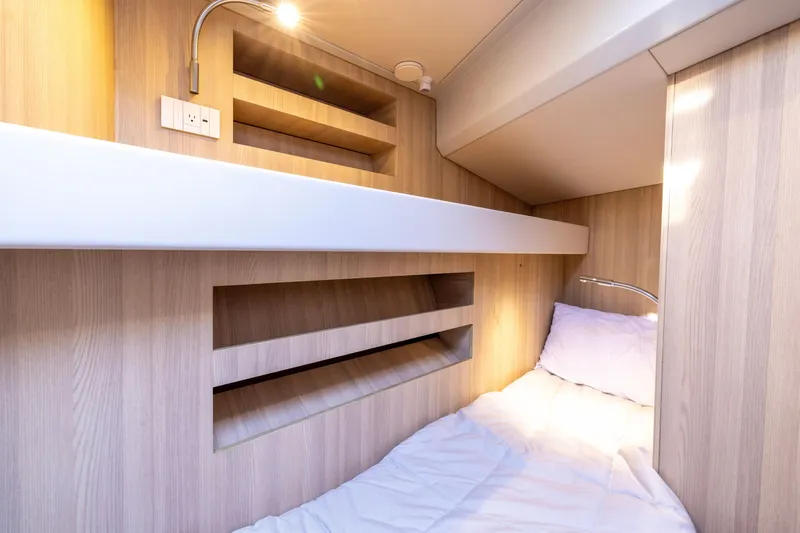 Slide: The Image of 2024 Bluegame BGX63 yacht cabin with modern wood interior and cozy bedding. - 82