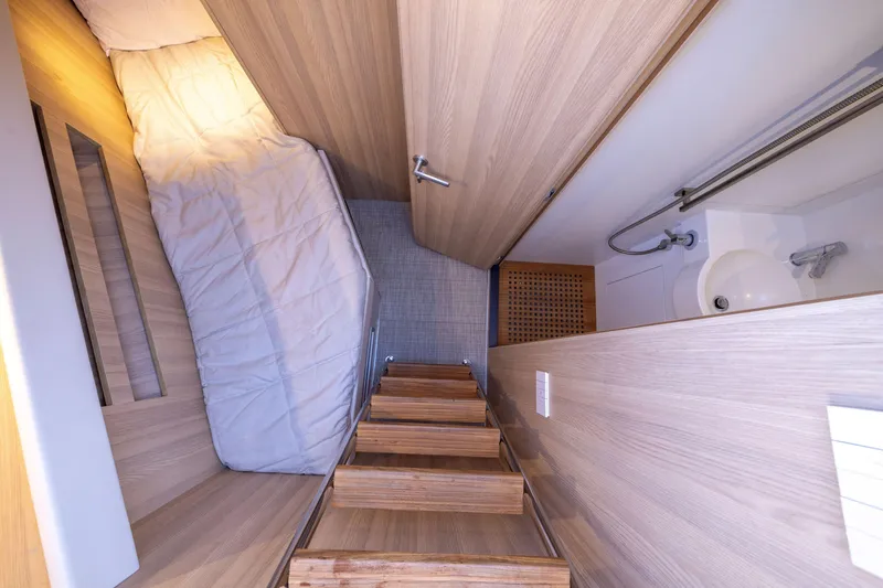 Slide: The Image of 2024 Bluegame BGX63 yacht interior with wooden stairs, cozy bed, and compact bathroom. - 84