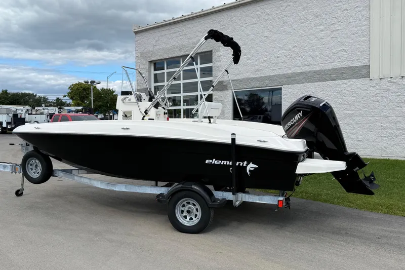 The Image of 2016 Bayliner Element F18 boat on trailer, parked outdoors near a building. - 0