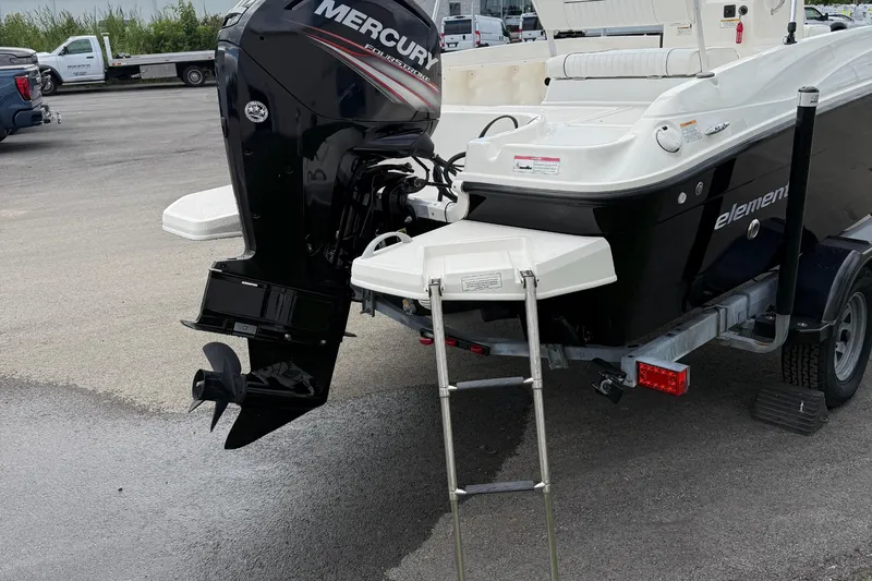 Slide: The Image of 2016 Bayliner Element F18 boat with Mercury outboard motor and ladder on trailer. - 17