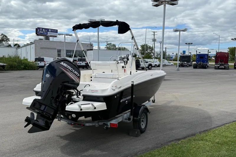 Slide: The Image of 2016 Bayliner Element F18 boat with Mercury engine on a trailer in a parking lot. - 24