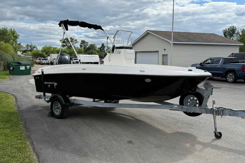 Slide: The Image of 2016 Bayliner Element F18 boat on trailer, parked outdoors under cloudy sky. - 31