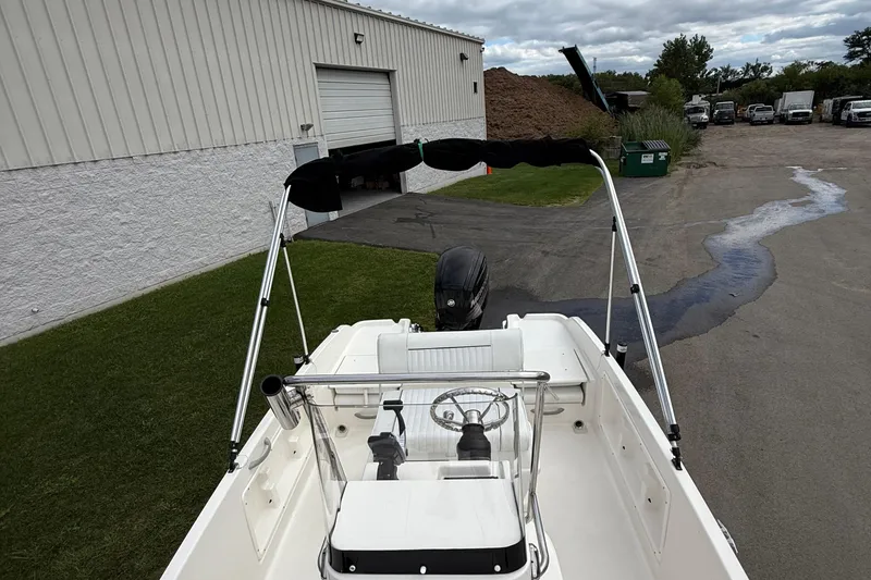 Slide: The Image of 2016 Bayliner Element F18 boat with canopy, parked near a warehouse. - 9