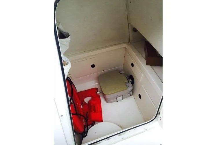 Slide: The Image of 2001 Boston Whaler 260 Outrage cabin interior with life jackets and portable toilet. - 17