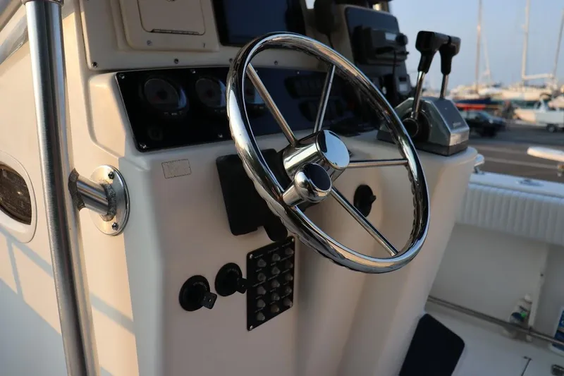 Slide: The Image of 2001 Boston Whaler 260 Outrage boat steering console with chrome wheel and controls. - 19