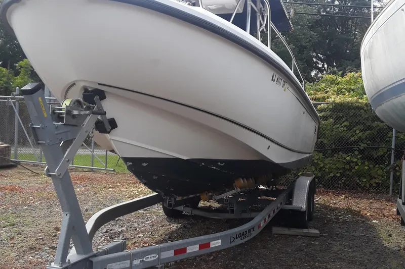 Slide: The Image of 2001 Boston Whaler 260 Outrage boat on trailer, parked outdoors. - 2