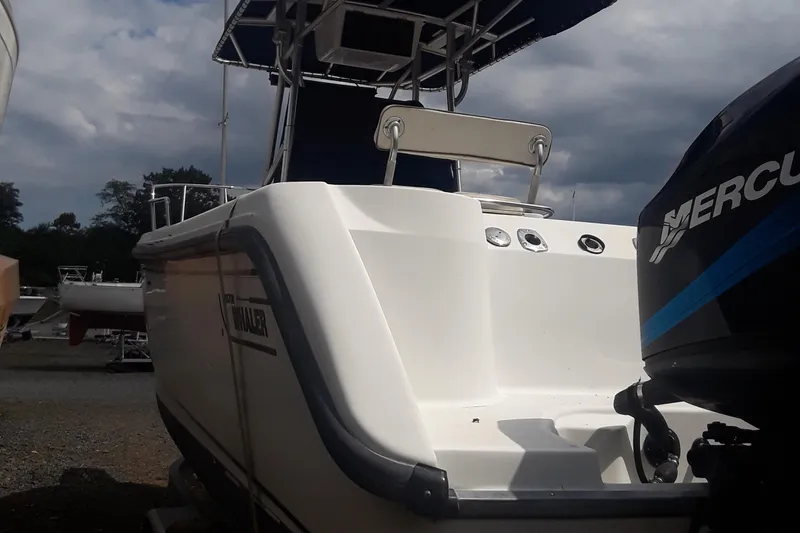 Slide: The Image of 2001 Boston Whaler 260 Outrage boat with Mercury engine, docked under cloudy skies. - 23