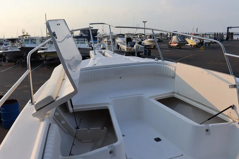 Slide: The Image of 2001 Boston Whaler 260 Outrage boat interior with open storage compartments at a marina. - 24