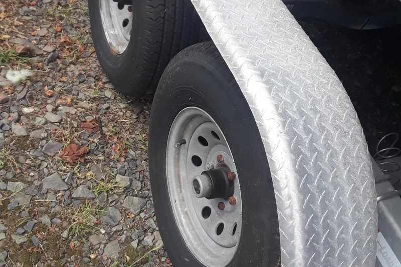 Slide: The Image of Trailer wheels and fender for 2001 Boston Whaler 260 Outrage on gravel surface. - 27