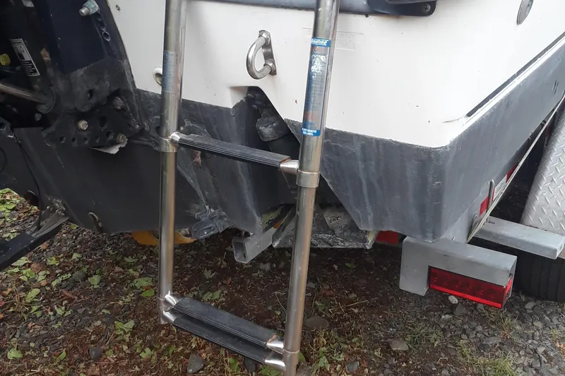 Slide: The Image of Rear view of a 2001 Boston Whaler 260 Outrage with a metal boarding ladder. - 8
