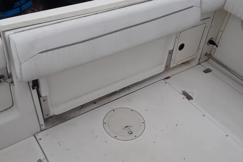 Slide: The Image of 2001 Boston Whaler 260 Outrage boat interior with white seating and storage compartments. - 9