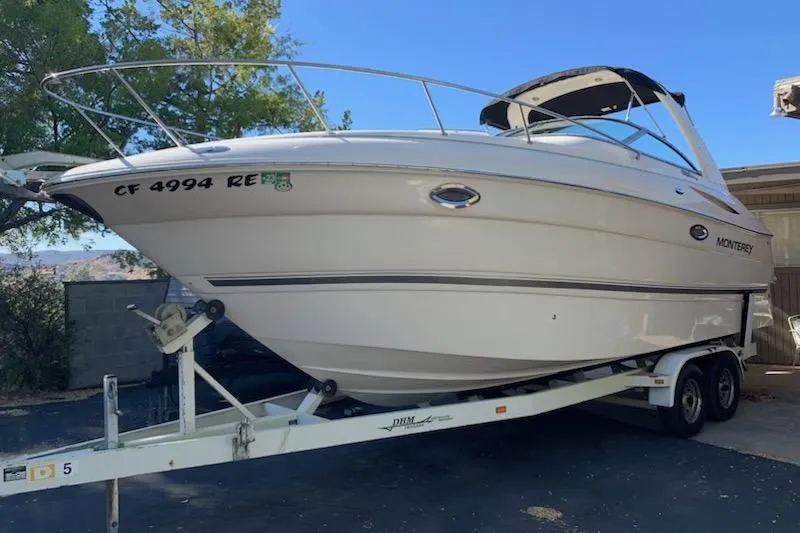 The Image of 2004 Monterey 265 Cruiser boat on trailer, parked outdoors. - 1