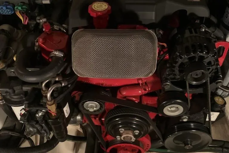 Slide: The Image of Engine of a 2004 Monterey 265 Cruiser boat, featuring red components and belts. - 12