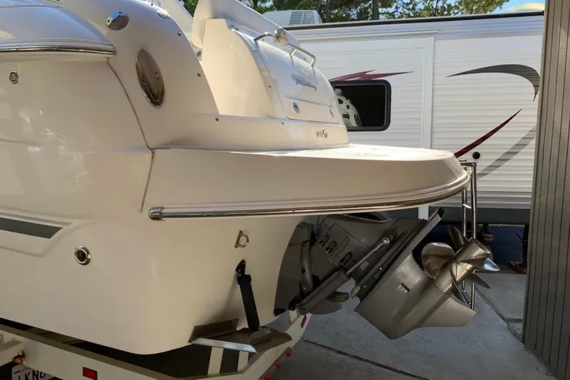 Slide: The Image of 2004 Monterey 265 Cruiser boat stern with propeller, parked near a trailer. - 13