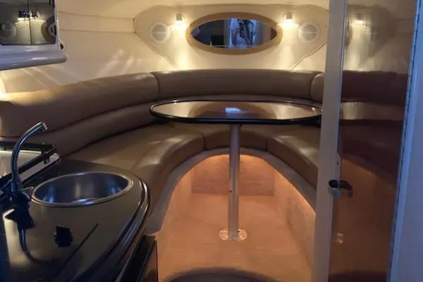 Slide: The Image of 2004 Monterey 265 Cruiser interior with cozy seating, table, and kitchenette. - 9