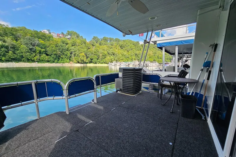 Slide: The Image of 2002 Jamestowner houseboat deck with seating, overlooking serene lake and lush green trees. - 14