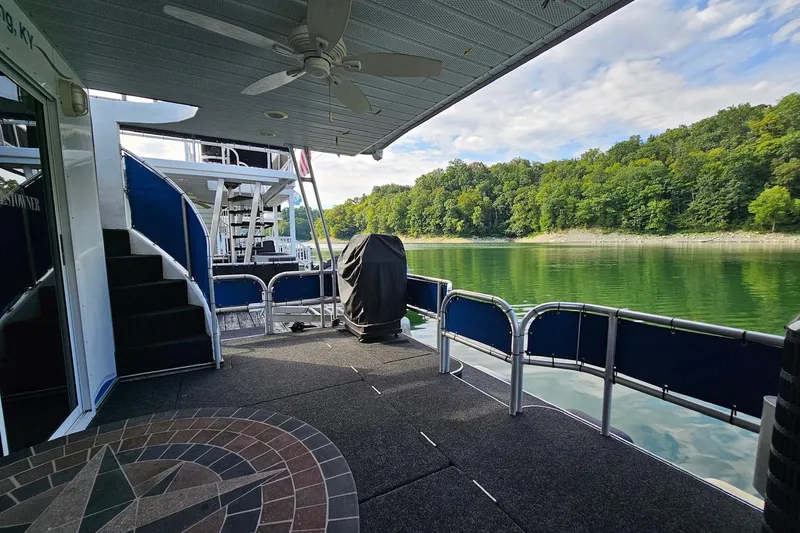 Slide: The Image of 2002 Jamestowner houseboat deck with scenic lake view and lush green shoreline. - 15