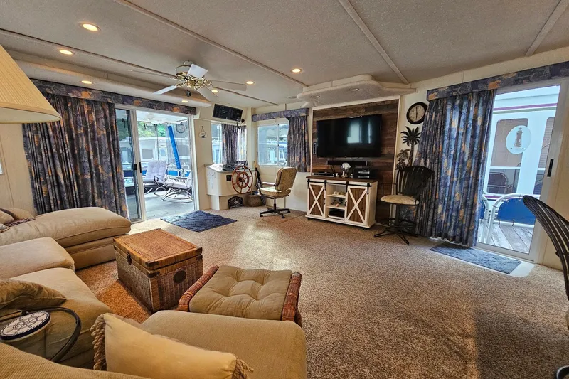 Slide: The Image of Spacious 2002 Jamestowner houseboat interior with cozy seating, TV, and nautical decor. - 17