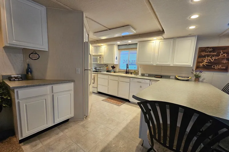 Slide: The Image of Spacious kitchen in 2002 Jamestowner houseboat with white cabinets and modern appliances. - 22
