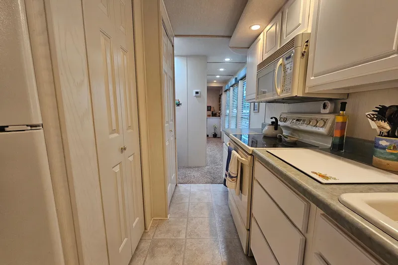 Slide: The Image of Modern kitchen interior of 2002 Jamestowner houseboat with white cabinetry and appliances. - 26