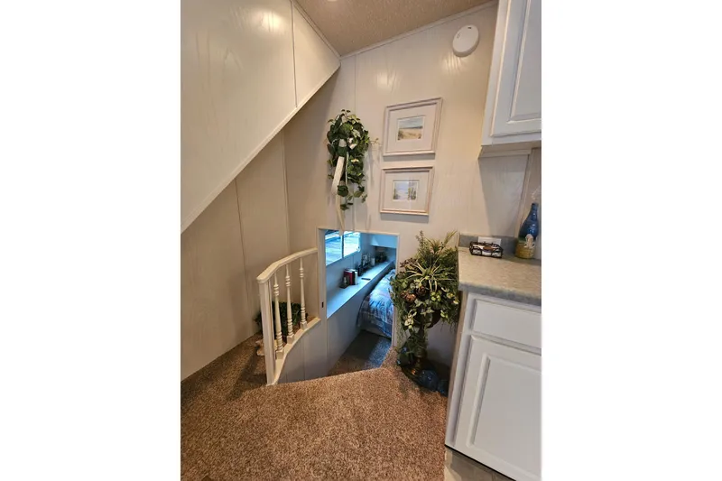 Slide: The Image of Interior of 2002 Jamestowner houseboat with cozy staircase and decorative plants. - 27