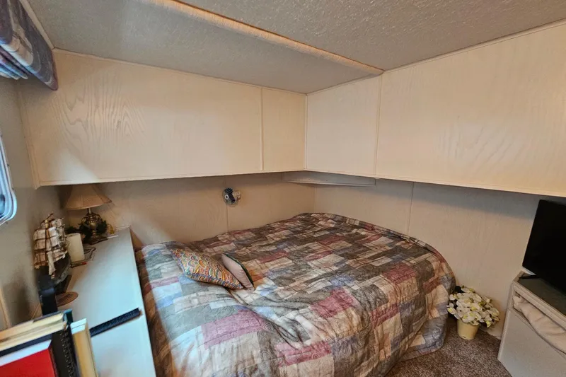 Slide: The Image of Cozy bedroom in 2002 Jamestowner houseboat with patterned bedspread and decorative items. - 28