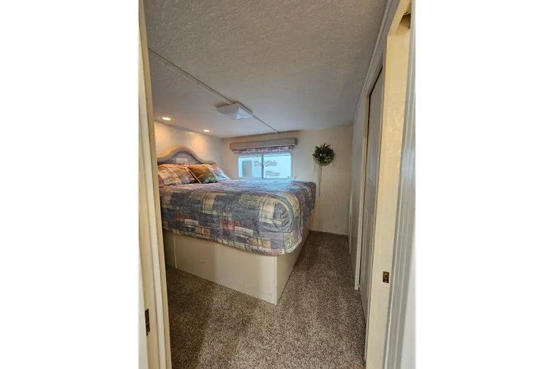 Slide: The Image of Cozy bedroom interior of 2002 Jamestowner houseboat with patterned bedding and soft lighting. - 30