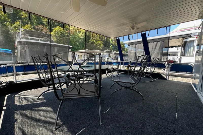Slide: The Image of Spacious 2002 Jamestowner houseboat deck with elegant metal chairs and scenic views. - 4