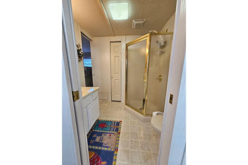 Slide: The Image of Bathroom in 2002 Jamestowner houseboat with shower, vanity, and colorful rug. - 41