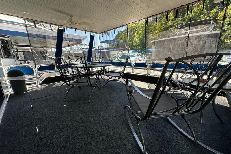 Slide: The Image of Spacious 2002 Jamestowner houseboat deck with chairs and table, surrounded by marina views. - 5