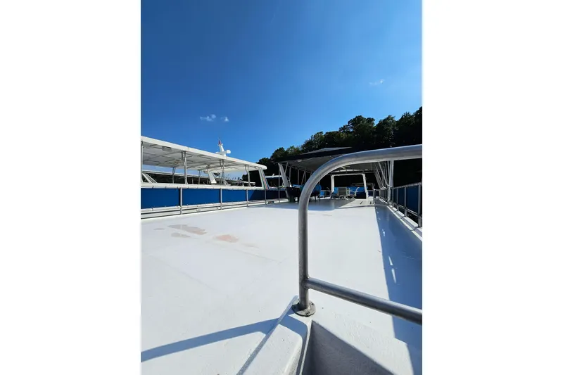Slide: The Image of 2002 Jamestowner houseboat deck with railing under clear blue sky. - 9