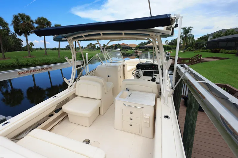 Slide: The Image of 2018 Grady-White Freedom 285 boat docked by a scenic canal with palm trees. - 10